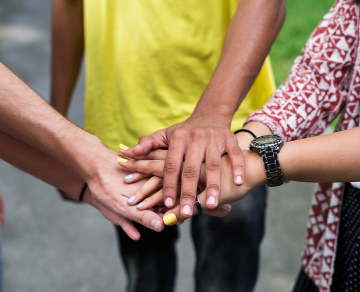 An image showing diverse team members collaborating, celebrating, and supporting one another